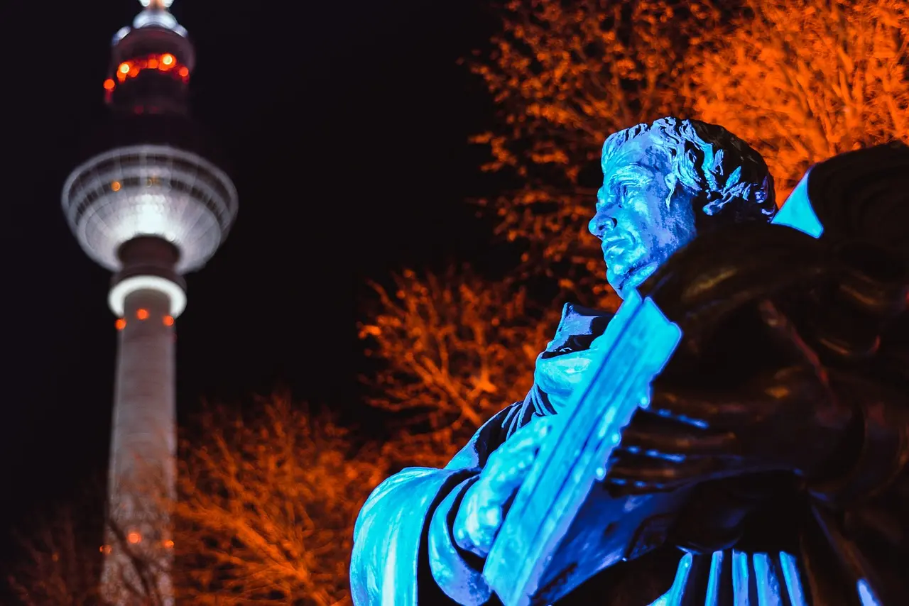 Statur von Martin Luther unter dem Berliner Fernsehturm bei Nacht